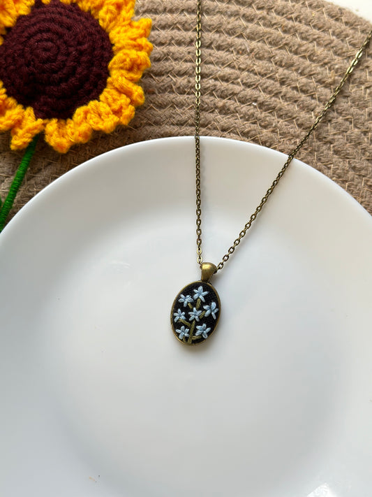 Hand-embroidered blue flowers pendant